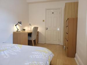 a bedroom with a bed and a desk with a lamp at Covent Garden Penthouse in London