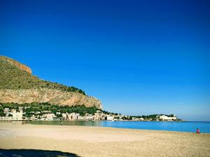 uitzicht op een strand met een stad op de achtergrond bij Green House Beach in Mondello