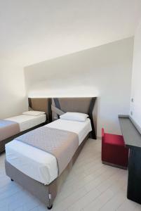 a small bedroom with two beds and a desk at Suite con giardino in La Maddalena