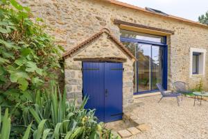 een blauwe deur op een stenen huis met een stoel bij Lovely Bleau in Perthes-en-Gâtinais