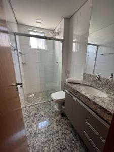 ein Badezimmer mit einem WC, einem Waschbecken und einem Spiegel in der Unterkunft Locking's Savassi 10 in Belo Horizonte