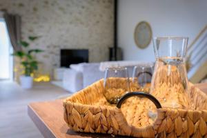 Una cesta con dos vasos y un jarrón sobre una mesa. en Lovely Bleau, en Perthes-en-Gâtinais