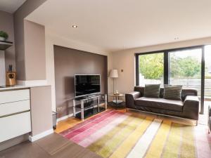 a living room with a couch and a flat screen tv at Underfell in Carnforth
