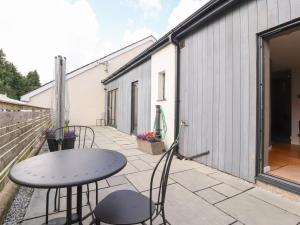 a patio with a table and chairs and a building at Underfell in Carnforth