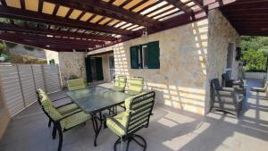 a patio with a table and chairs on a patio at Angelo’s villa in Avliótai