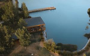 an aerial view of a house on the edge of a lake at L'AND Vineyards in Montemor-o-Novo