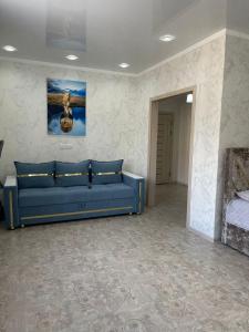 a blue couch in a room with a bed at ЖК ПРЕСТИЖ 1 комнатная квартира in Kokshetau