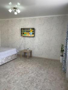 a bedroom with a bed and a painting on the wall at ЖК ПРЕСТИЖ 1 комнатная квартира in Kokshetau