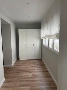 an empty room with white cabinets and wood floors at Precioso y céntrico apartamento in Zaragoza