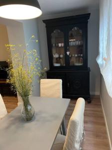 Precioso y céntrico apartamento في سرقسطة: غرفة طعام مع طاولة بيضاء وخزانة سوداء
