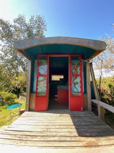 una piccola casa con porte rosse e una rampa di accesso in legno di Bohémienne regarde la mer. a Plogoff