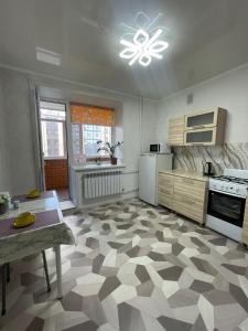 a kitchen with a checkered flooring in a room at ЖК ПРЕСТИЖ 1 комнатная квартира in Kokshetau