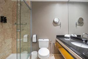a bathroom with a toilet and a sink and a shower at Full Jazz by Slaviero Hotéis in Curitiba