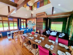 a dining room with a large table and chairs at DooNa Resort แลภูดูนา in Ban San Pa Sak