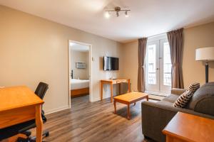 uma sala de estar com um sofá e um quarto com uma cama em Hotel le Roberval em Montréal