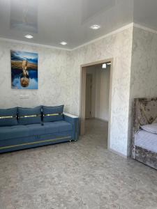 a room with a blue couch and a bed at ЖК ПРЕСТИЖ 1 комнатная квартира in Kokshetau