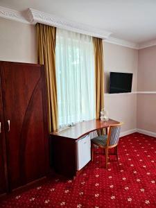 a room with a desk and a chair and a window at Gala Hotel in Pforzheim