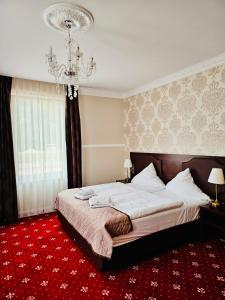 プフォルツハイムにあるGala Hotelのベッドルーム1室(大型ベッド1台、シャンデリア付)