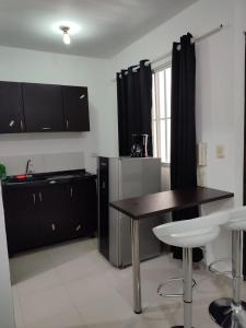 a kitchen with black cabinets and a table and chairs at Loft en San Fernando 106 in Cali