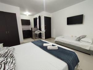 a hotel room with two beds and a tv at Loft en San Fernando 106 in Cali