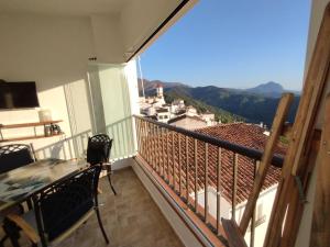 a balcony with a table and chairs and a view at Casa Perejil, un balcón al Genal in Genalguacil