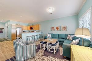 a living room with a blue couch and a kitchen at Oyster Bay Villas --- 20411 Jeb Dr, Unit #36 in Rehoboth Beach
