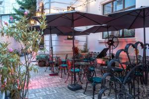 Un patio con mesas y sillas y una sombrilla. en Conacul Coroanei Luxury Boutique Hotel, en Bucarest 40 fotos más