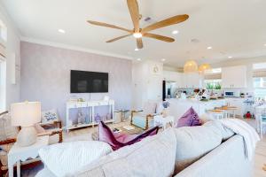 uma sala de estar com um sofá e uma ventoinha de tecto em The Purple Pelican em Galveston