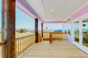 a wooden porch with a view of the ocean at The Purple Pelican in Galveston