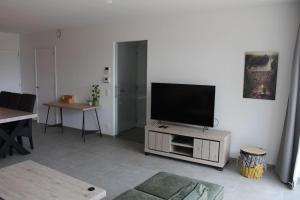 Il comprend un salon doté d'une télévision à écran plat. dans l'établissement Ruim nieuwbouwappartement oostduinkerke, à Oostduinkerke