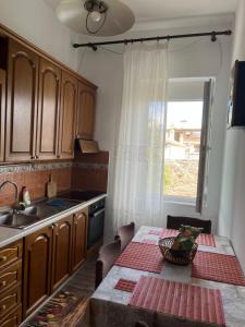 a kitchen with a table and a sink and a window at Lukas Apartament Vollga Durres in Durrës