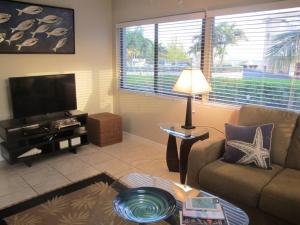 a living room with a couch and a flat screen tv at Fabulous one bedroom in West Bay in West Bay