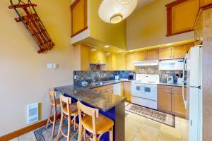 a large kitchen with a island with stools in it at Tree Tops 12 - Suite in Big White