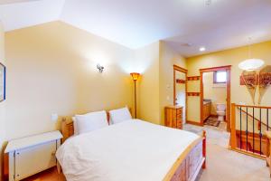 1 dormitorio con 1 cama grande y baño en Tree Tops 12 - Suite, en Big White
