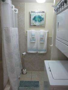 ein Bad mit einer Dusche, einem WC und Handtüchern in der Unterkunft Fabulous one bedroom in West Bay in West Bay