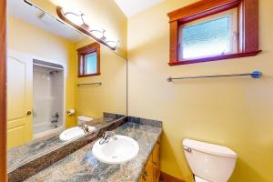 a bathroom with a sink and a toilet and a mirror at Tree Tops 12 - Suite in Big White