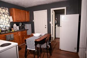 a kitchen with a table and a white refrigerator at Couple Getaway 5 mins from Downtown in Knoxville