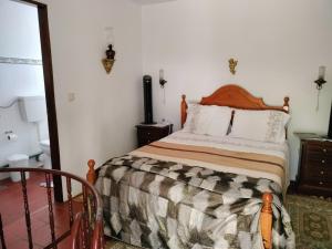 1 dormitorio con 1 cama con cabecero de madera en Casa da Lomba, en Arganil