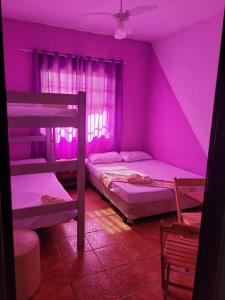 Habitación púrpura con 2 literas y ventana en Pousada das Artes 2 en Mongaguá