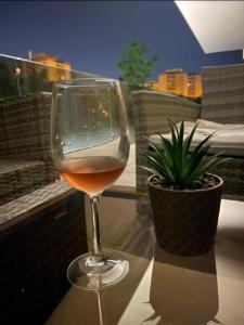 a glass of wine sitting on a table with a plant at Plaza Residence in Braşov