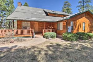Casa de madera con techo de metal y porche en Pine Cone Cabin, en Pinetop-Lakeside