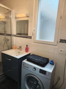 ein Badezimmer mit einer Waschmaschine und einem Waschbecken in der Unterkunft Stylish flat in a quiet area close to amenities in Melun