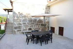 a table and chairs with an umbrella on a patio at Refúgio dos 3 Passos in Lanhas