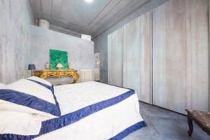 um quarto com uma cama com um cobertor azul e branco em Art Gallery Apartment em Génova mais 11 fotografias