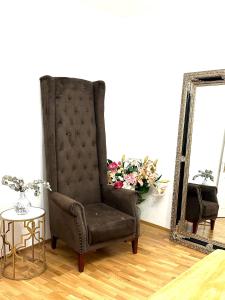 una silla negra en una habitación con espejo en City center Apartment, en Viena
