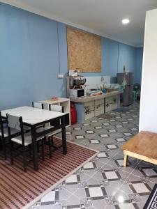 ein Zimmer mit einem Tisch und Stühlen auf einem Fliesenboden in der Unterkunft Homestay Kenangan Kemaman in Cukai