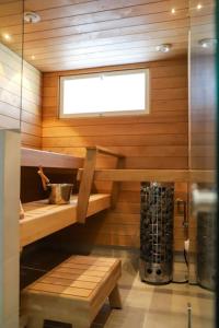 a sauna with a bench and a window in a room at Big apartment, near Santaclaus Village in Rovaniemi