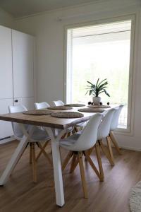 a white dining room with a table and chairs at Big apartment, near Santaclaus Village in Rovaniemi
