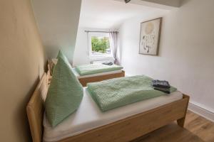a room with two beds with green pillows at sehusa living in Seesen