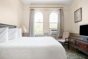 um quarto de hotel com uma cama e uma televisão em Hotel St. Michael em Prescott